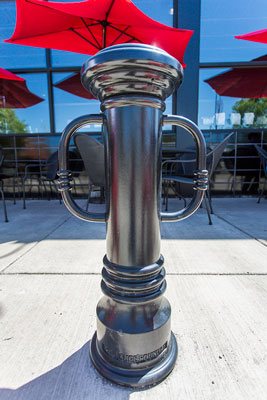 装饰的黑色自行车护柱站在咖啡馆的红色雨伞前